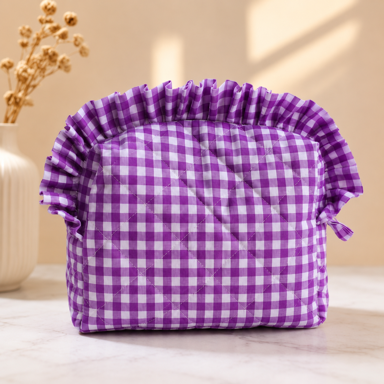 Purple and white checkered fabric bag with ruffled edges on a light background