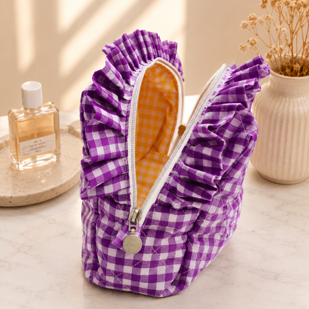 Purple checkered pouch with ruffles on a neutral background